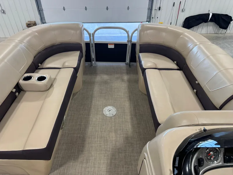 Slide: The Image of 2018 Sun Tracker Party Barge 22 DLX interior with beige seating and cup holders. - 9