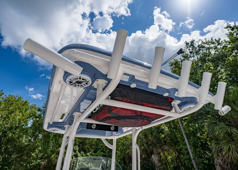 Slide: The Image of 2024 Caymas 26 HB boat top view with rod holders under a sunny sky. - 13