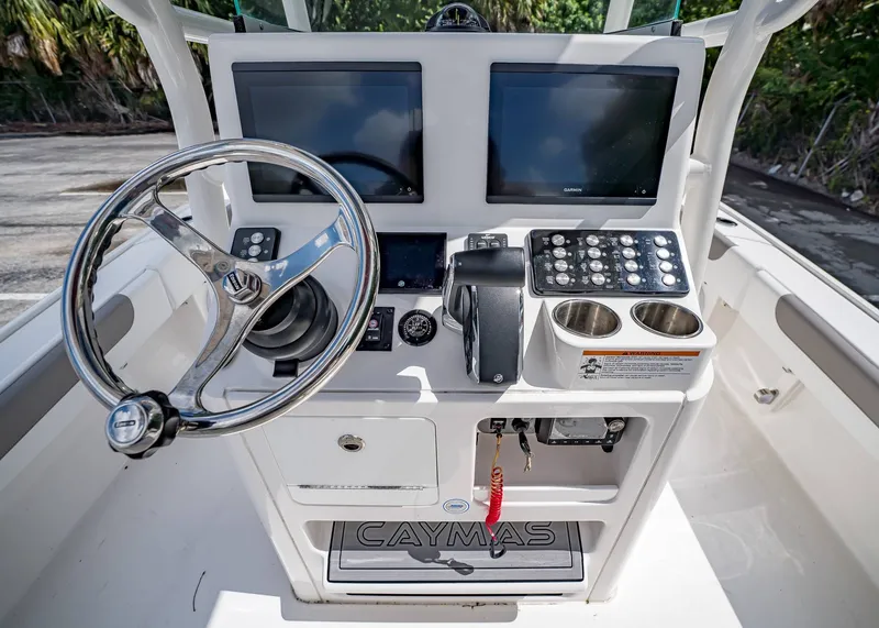 Slide: The Image of 2024 Caymas 26 HB boat console with dual screens, steering wheel, and control panel. - 15