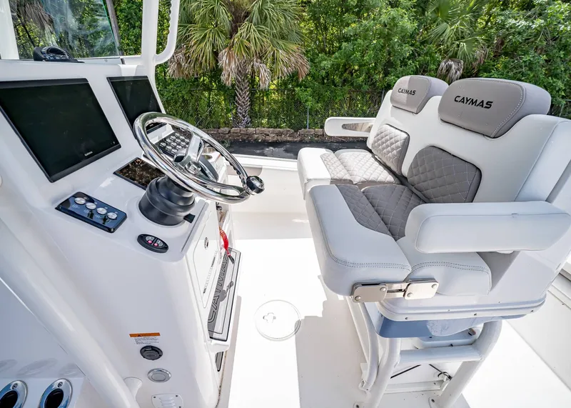 Slide: The Image of 2024 Caymas 26 HB boat interior with steering wheel and cushioned seating. - 17