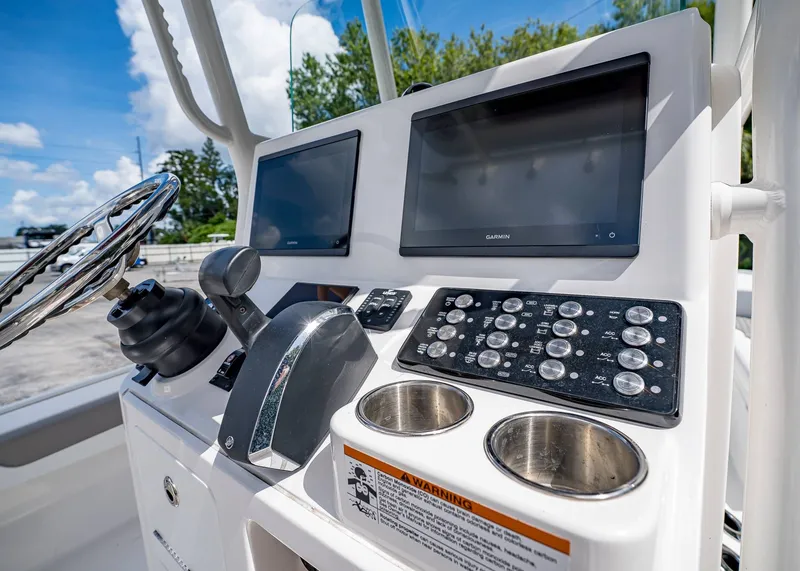 Slide: The Image of 2024 Caymas 26 HB boat dashboard with dual Garmin screens and control panel. - 20