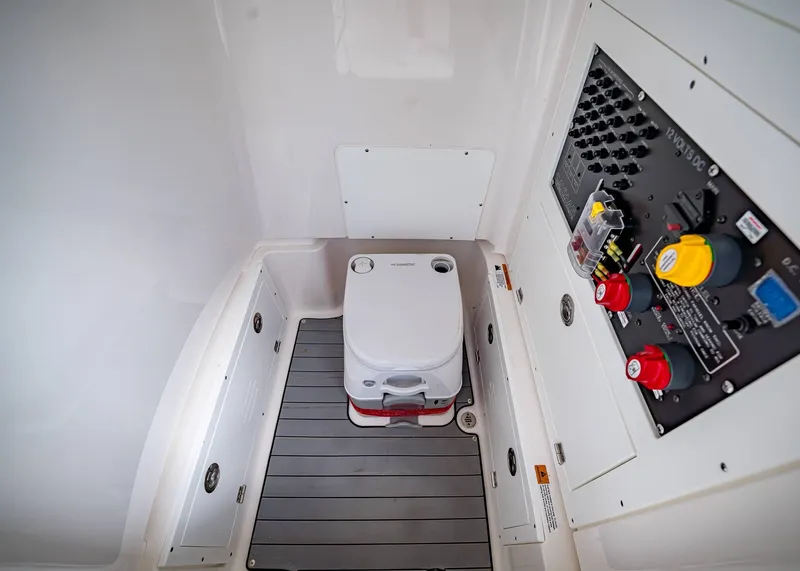 Slide: The Image of 2024 Caymas 26 HB boat interior with portable toilet and control panel. - 23