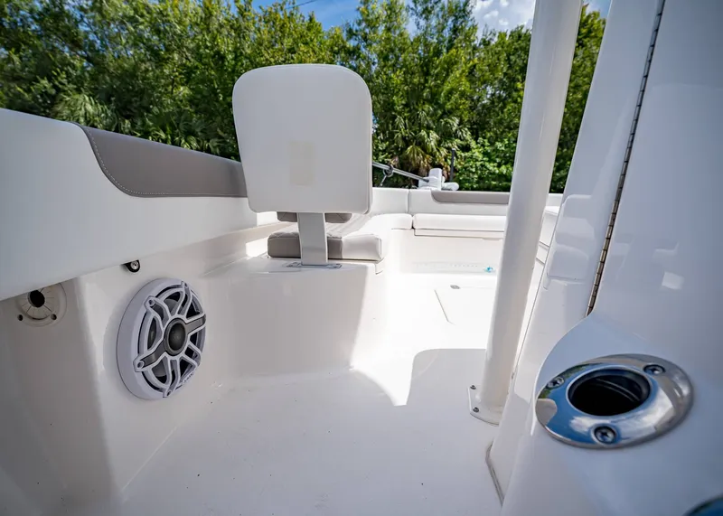 Slide: The Image of 2024 Caymas 26 HB boat interior with seating and speaker, surrounded by lush greenery. - 28