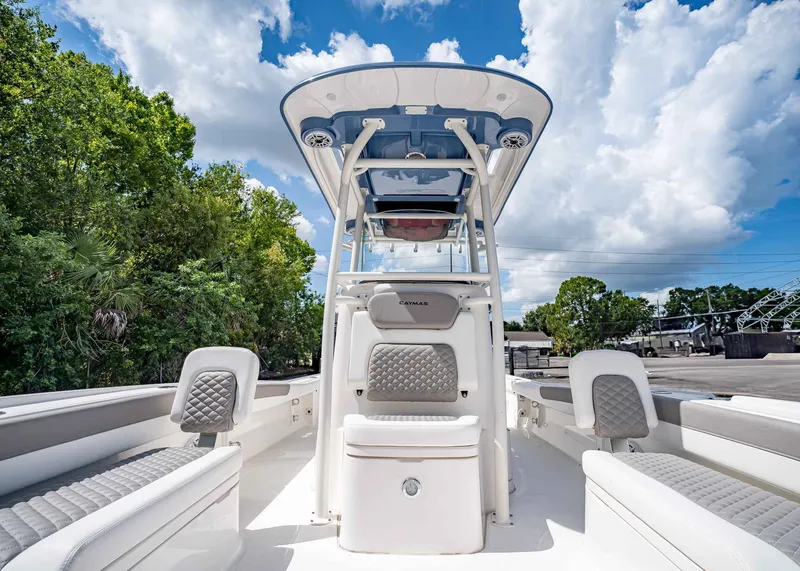 Slide: The Image of 2024 Caymas 26 HB boat with sleek seating and canopy under a blue sky. - 29