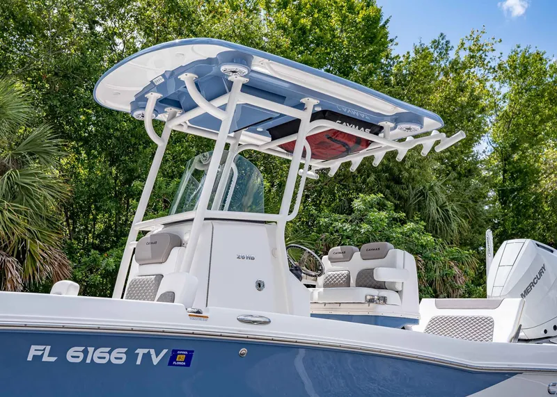 Slide: The Image of 2024 Caymas 26 HB boat with T-top, set against lush greenery. - 3