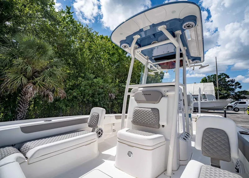 Slide: The Image of 2024 Caymas 26 HB boat interior with seating and T-top under a blue sky. - 31