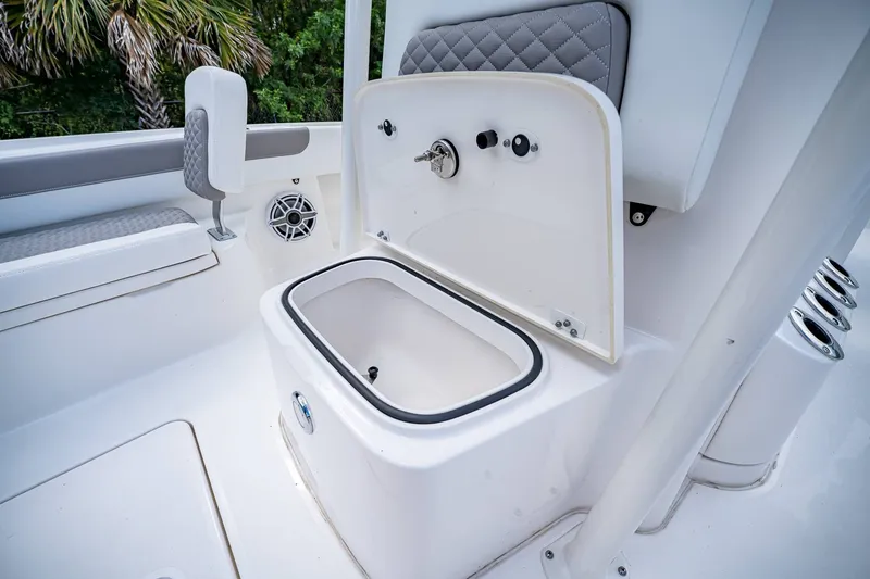 Slide: The Image of 2024 Caymas 26 HB boat interior with open storage compartment and seating. - 33