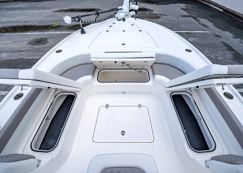 Slide: The Image of 2024 Caymas 26 HB boat deck with open storage compartments and seating. - 35