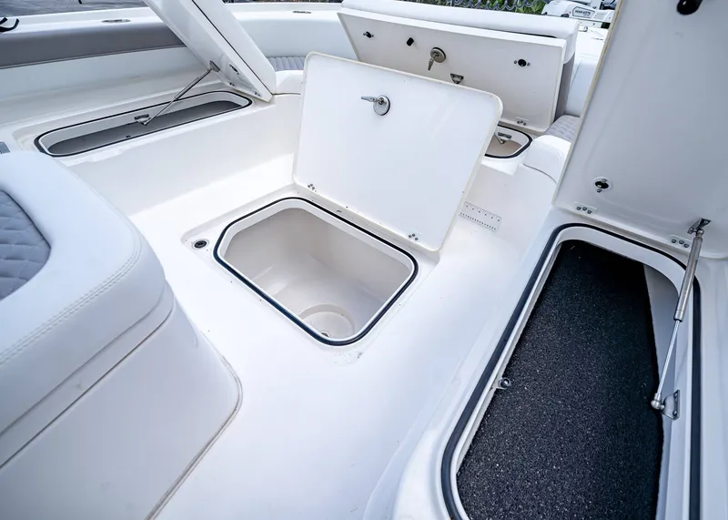 Slide: The Image of 2024 Caymas 26 HB boat storage compartments with open hatches, showcasing spacious interior design. - 36