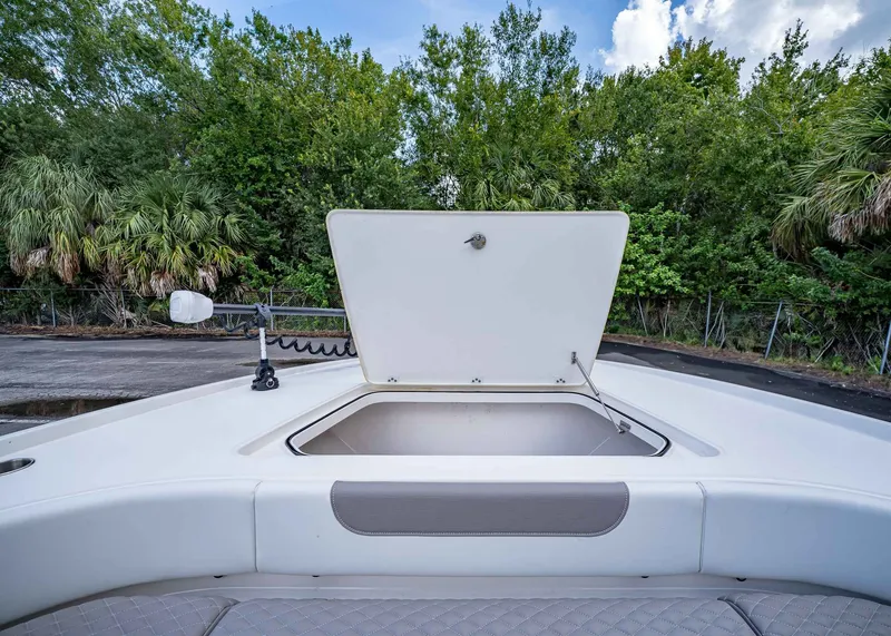Slide: The Image of 2024 Caymas 26 HB boat with open storage compartment, surrounded by lush greenery. - 37