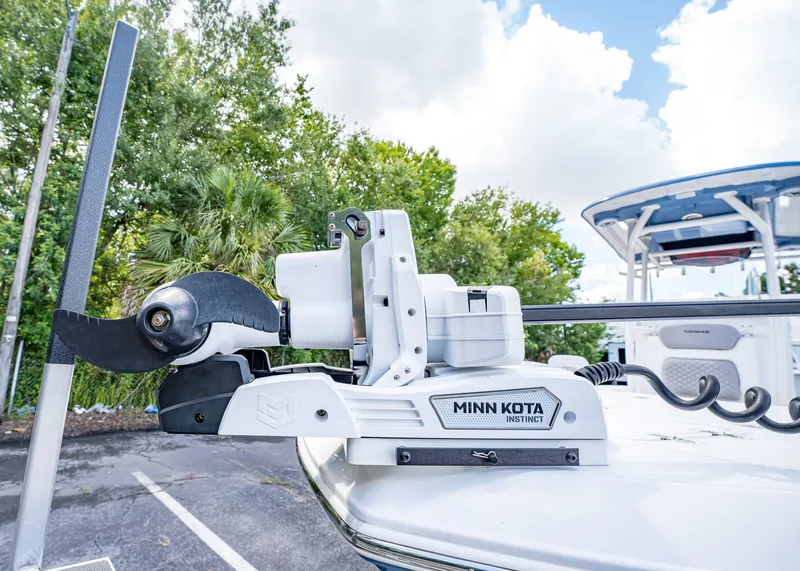 Slide: The Image of 2024 Caymas 26 HB boat with Minn Kota Instinct trolling motor, parked outdoors. - 5