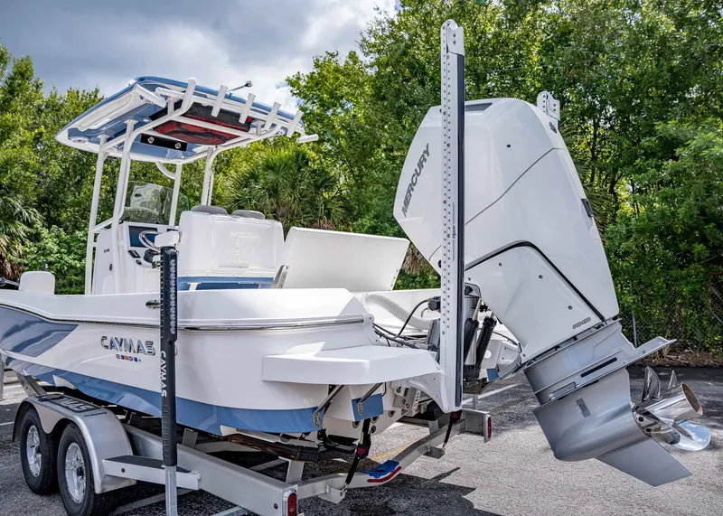 Slide: The Image of 2024 Caymas 26 HB boat on trailer with Mercury engine, parked outdoors. - 7