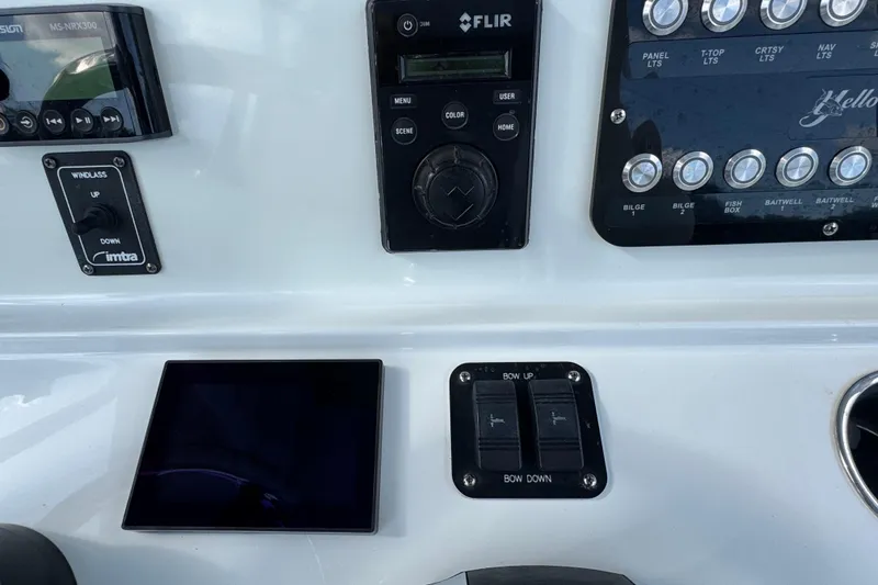 Slide: The Image of Control panel of a 2020 Yellowfin 36 Offshore boat with various switches and displays. - 64
