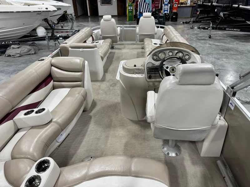 Slide: The Image of 2008 Crest III 2570 pontoon boat interior with beige seating and steering console. - 6