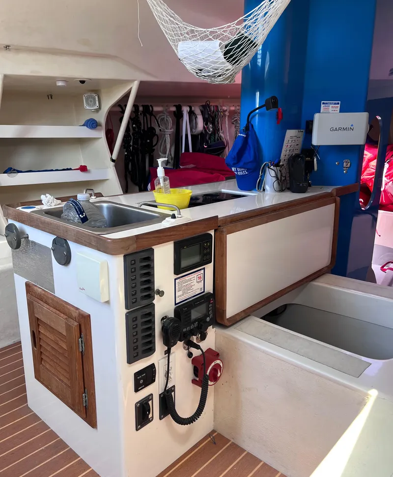 Slide: The Image of Interior of 2009 Class 40 Antrim Design yacht with navigation equipment and compact kitchen area. - 25
