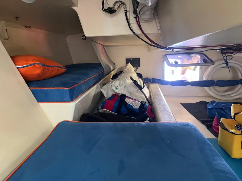 Slide: The Image of Interior of 2009 Class 40 Antrim Design yacht with blue cushions and storage bags. - 28
