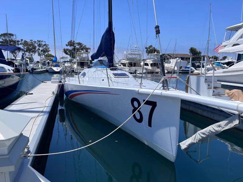 Slide: The Image of Sleek 2009 Class 40 Antrim Design sailboat docked in a marina, numbered 87. - 3