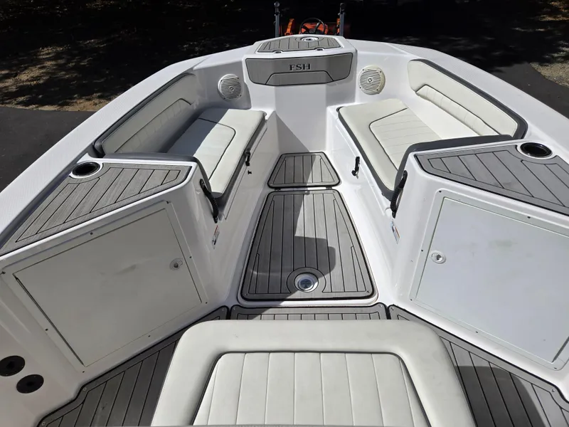 Slide: The Image of 2022 Yamaha Boats 210 FSH Deluxe interior with cushioned seating and storage compartments. - 11