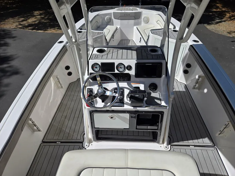 Slide: The Image of 2022 Yamaha Boats 210 FSH Deluxe cockpit with steering wheel and controls. - 12