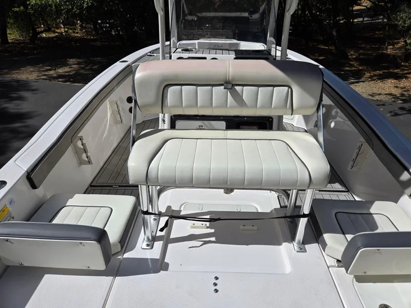 Slide: The Image of 2022 Yamaha Boats 210 FSH Deluxe interior with white seating and sleek design. - 14