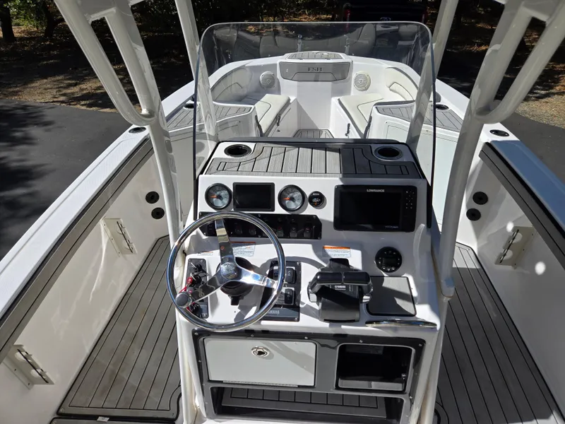 Slide: The Image of 2022 Yamaha Boats 210 FSH Deluxe dashboard with steering wheel and navigation controls. - 16