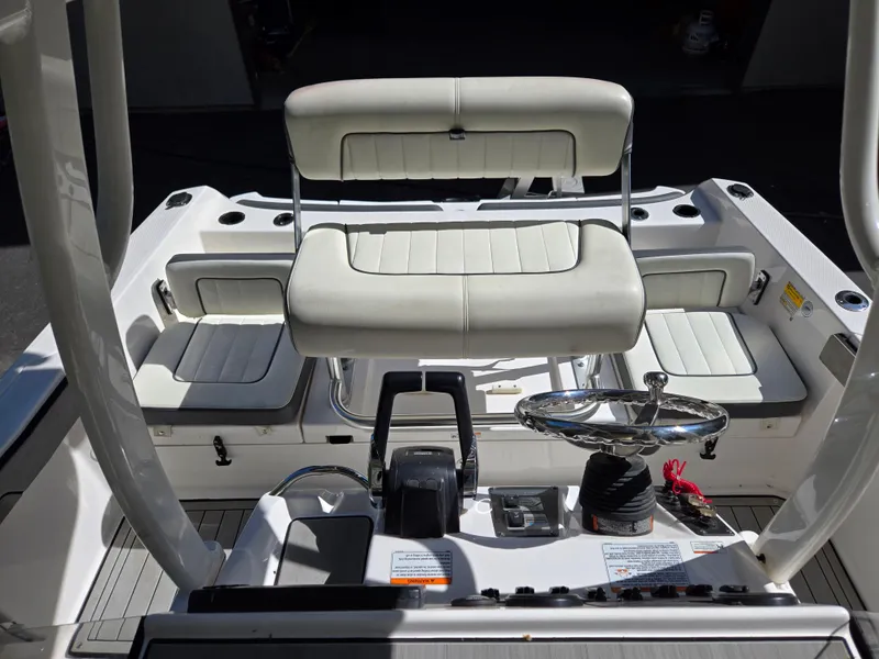 Slide: The Image of 2022 Yamaha Boats 210 FSH Deluxe interior with seating and steering wheel. - 17
