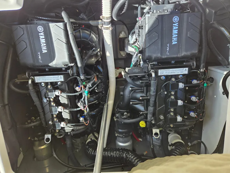 Slide: The Image of Engine compartment of a 2022 Yamaha Boats 210 FSH Deluxe, showcasing dual Yamaha TR-1 engines. - 18