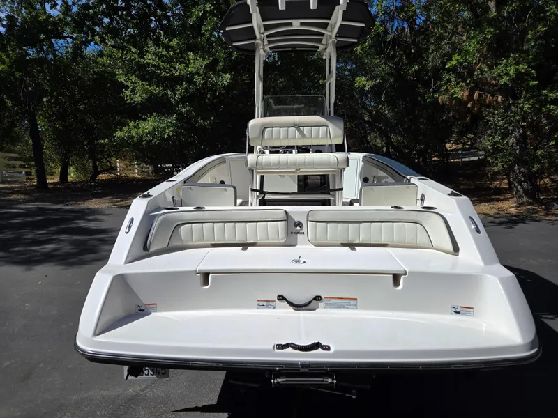 Slide: The Image of 2022 Yamaha Boats 210 FSH Deluxe, rear view, white seating, outdoor setting. - 19