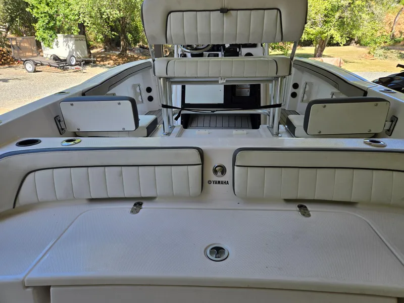 Slide: The Image of 2022 Yamaha Boats 210 FSH Deluxe interior with white seating and storage compartments. - 23