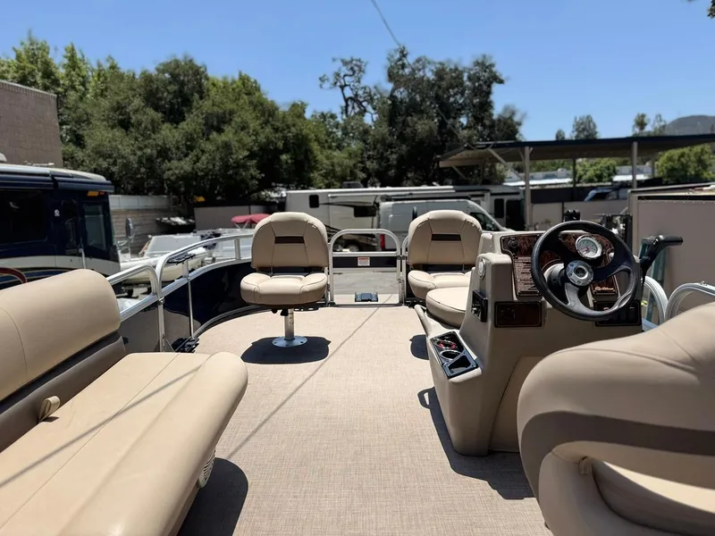 Slide: The Image of 2023 Sun Tracker Bass Buggy 16 XL Select pontoon boat interior with beige seating and steering console. - 10