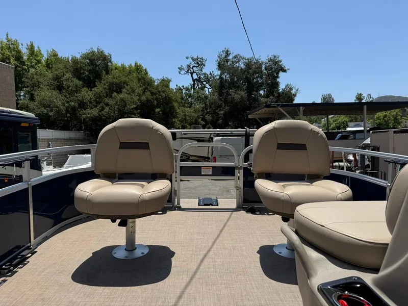 Slide: The Image of 2023 Sun Tracker Bass Buggy 16 XL Select pontoon boat with beige seating, outdoor setting. - 13