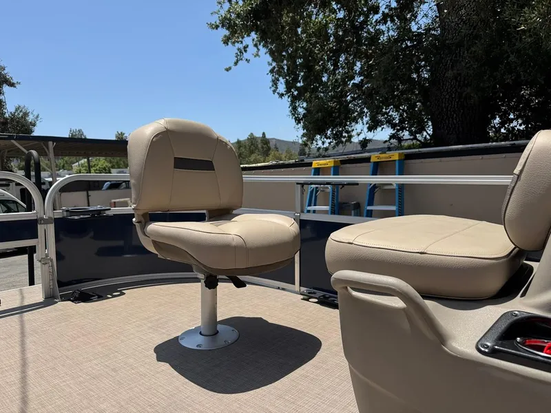 Slide: The Image of 2023 Sun Tracker Bass Buggy 16 XL Select boat seats under clear blue sky. - 16