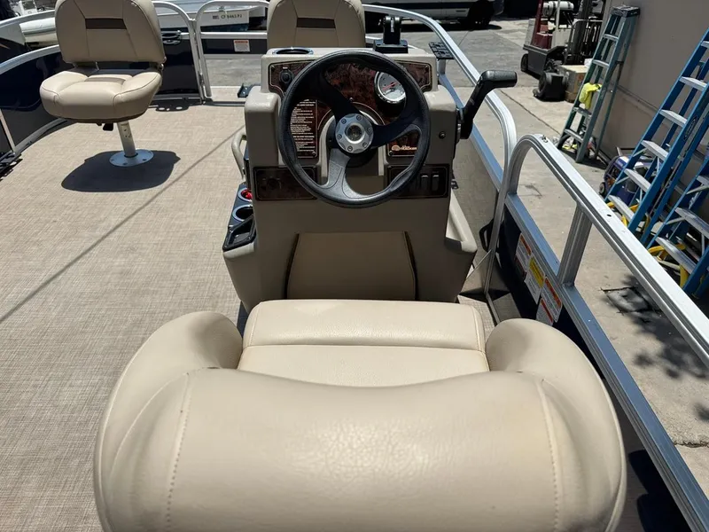 Slide: The Image of 2023 Sun Tracker Bass Buggy 16 XL Select interior with steering wheel and beige seating. - 17