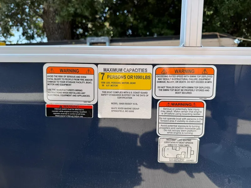 Slide: The Image of Warning labels on 2023 Sun Tracker Bass Buggy 16 XL Select boat, indicating capacity and safety instructions. - 18