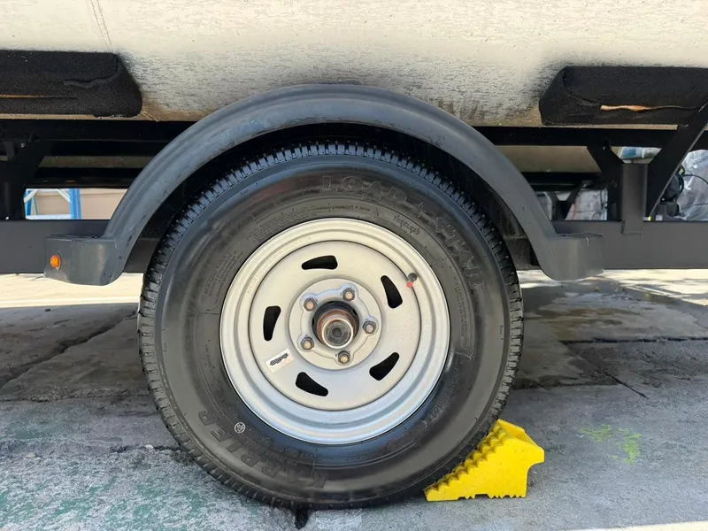 Slide: The Image of Trailer wheel of 2023 Sun Tracker Bass Buggy 16 XL Select, secured with a yellow chock. - 20