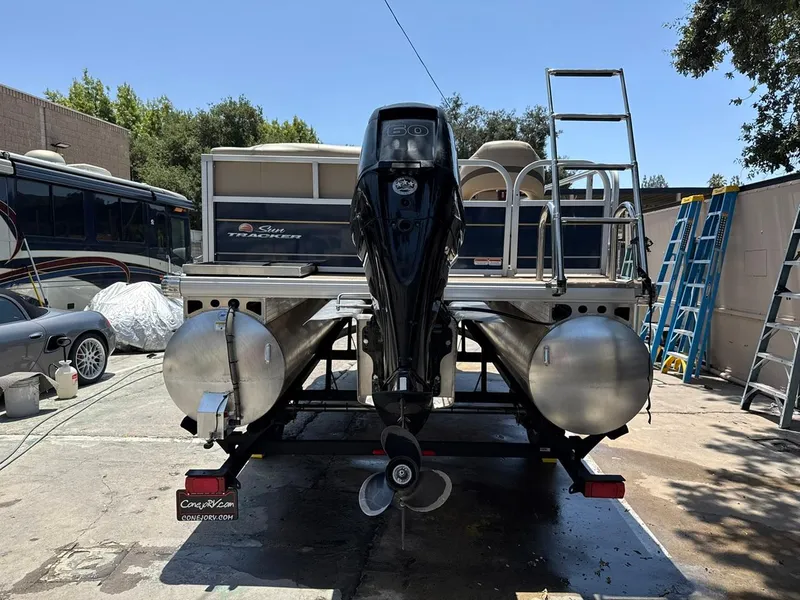 Slide: The Image of 2023 Sun Tracker Bass Buggy 16 XL Select pontoon boat with outboard motor, parked outdoors. - 28