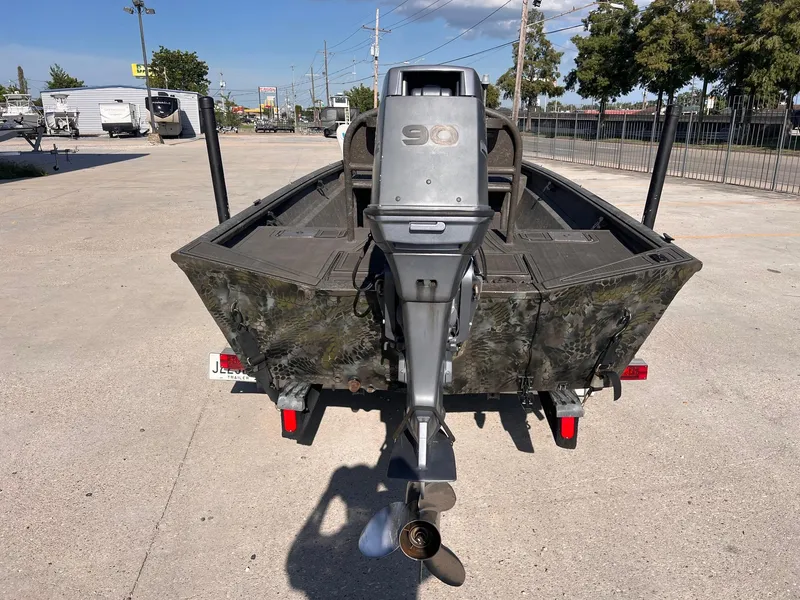 Slide: The Image of 2007 Lakesport 1860 boat with outboard motor, parked on a trailer in a lot. - 4