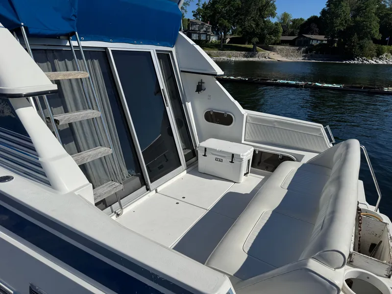 Slide: The Image of 1990 Carver 30 Santego boat deck with seating, cooler, and water view. - 3