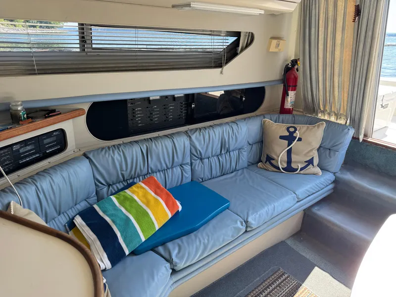 Slide: The Image of Interior of 1990 Carver 30 Santego with blue seating, anchor pillow, and colorful towel. - 10