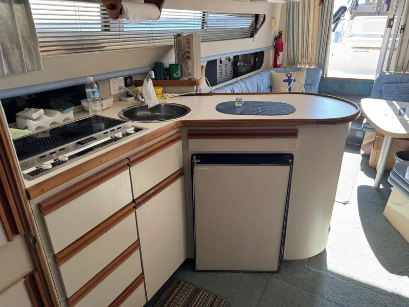 Slide: The Image of Interior of a 1990 Carver 30 Santego yacht with kitchen and seating area. - 11