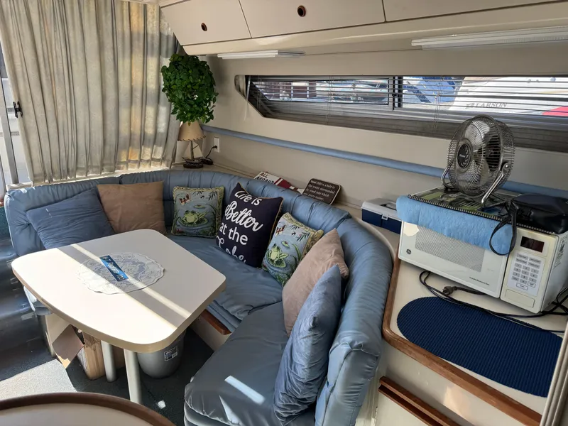 Slide: The Image of Cozy interior of 1990 Carver 30 Santego with cushioned seating and microwave. - 9