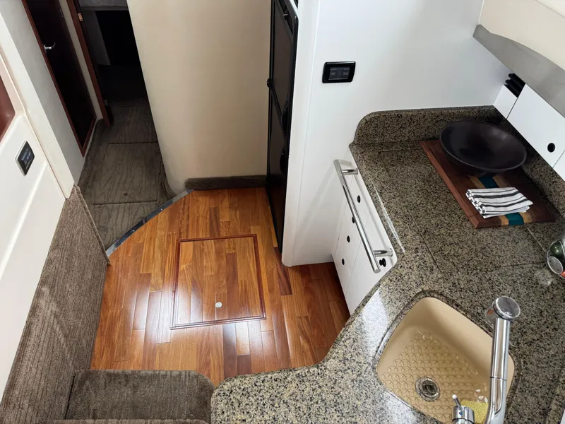 Slide: The Image of 2005 Sea Ray 420 Sedan Bridge interior with granite countertops and wooden flooring. - 12