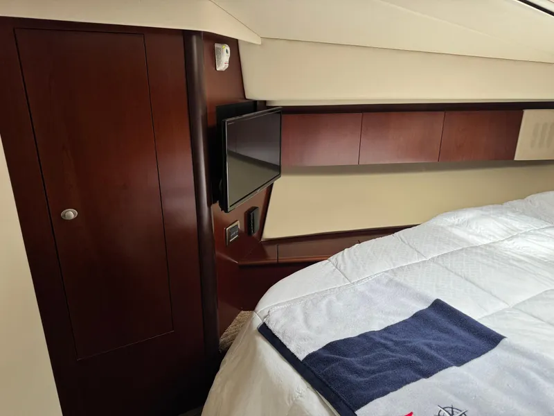 Slide: The Image of Luxurious cabin interior of 2005 Sea Ray 420 Sedan Bridge with TV and wood cabinetry. - 19