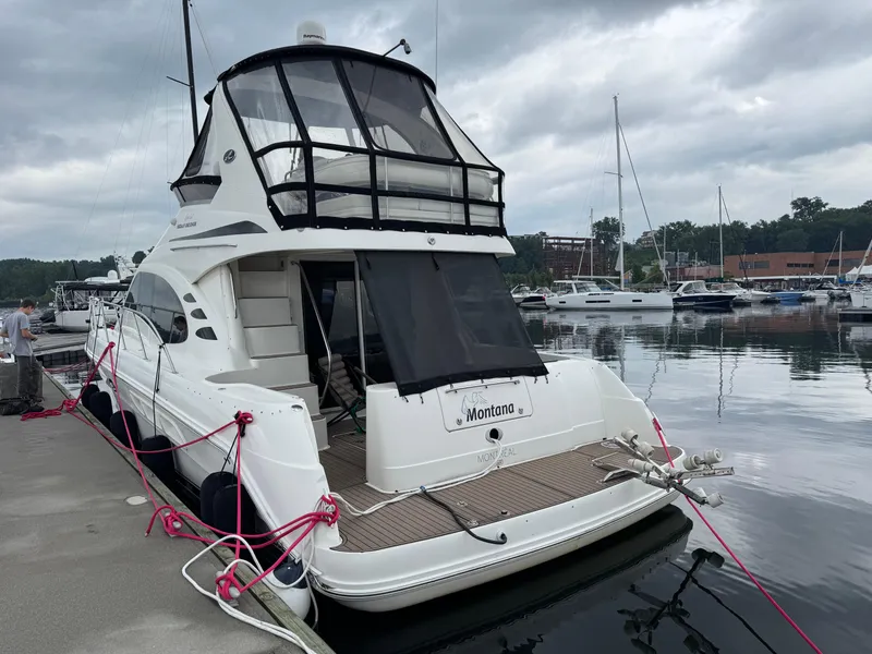 Slide: The Image of 2005 Sea Ray 420 Sedan Bridge yacht docked at marina, overcast sky. - 2
