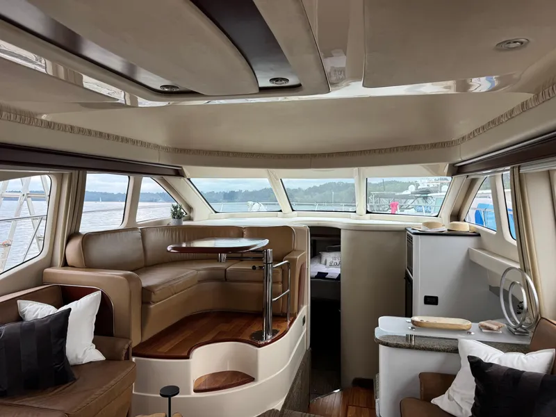 Slide: The Image of Luxurious interior of 2005 Sea Ray 420 Sedan Bridge yacht with elegant seating and panoramic windows. - 5