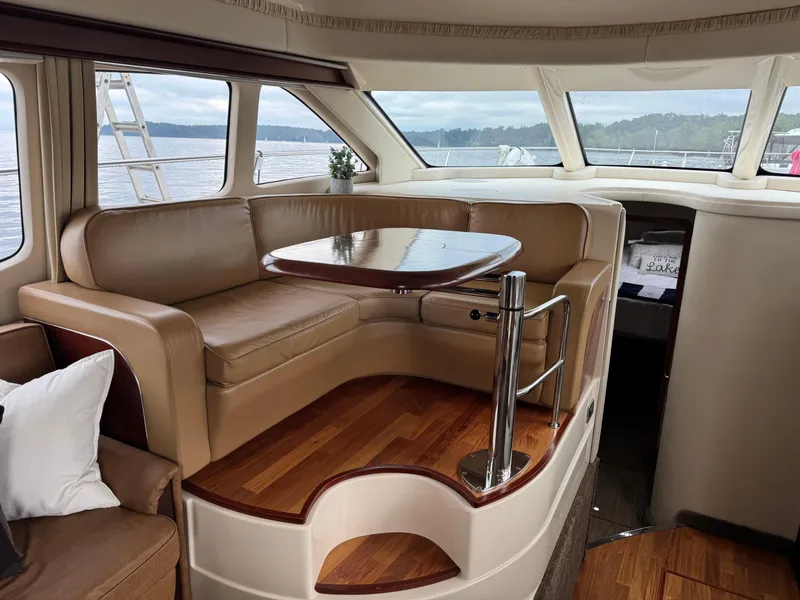 Slide: The Image of Luxurious interior of 2005 Sea Ray 420 Sedan Bridge with leather seating and wooden flooring. - 6