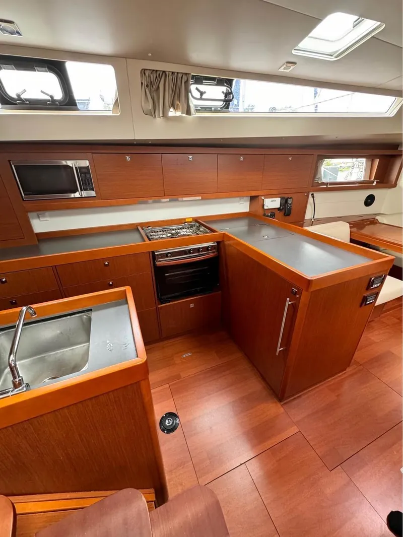 Slide: The Image of Interior of 2013 Beneteau Oceanis 48 yacht kitchen with wood finish and modern appliances. - 5