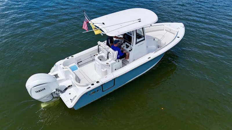 The Image of 2024 Sea Hunt Ultra 239 SE boat on water, featuring Yamaha engine and American flag. - 0