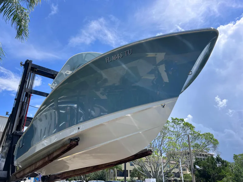 Slide: The Image of 2024 Sea Hunt Ultra 239 SE boat on lift under clear blue sky. - 12