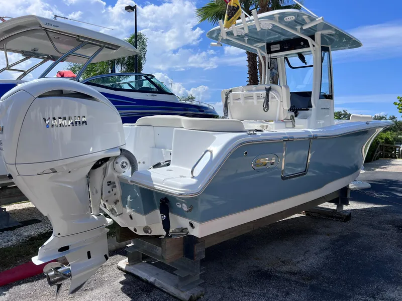 Slide: The Image of 2024 Sea Hunt Ultra 239 SE boat with Yamaha engine, displayed outdoors. - 13